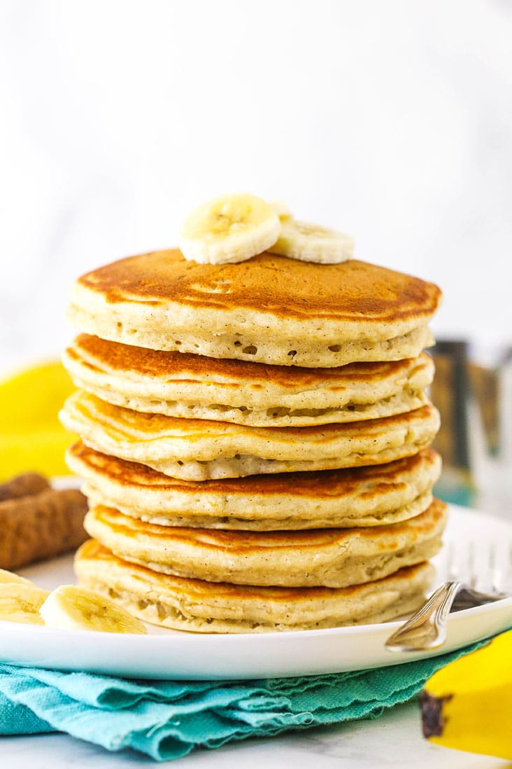 A stack of fluffy pancakes topped with banana slices
