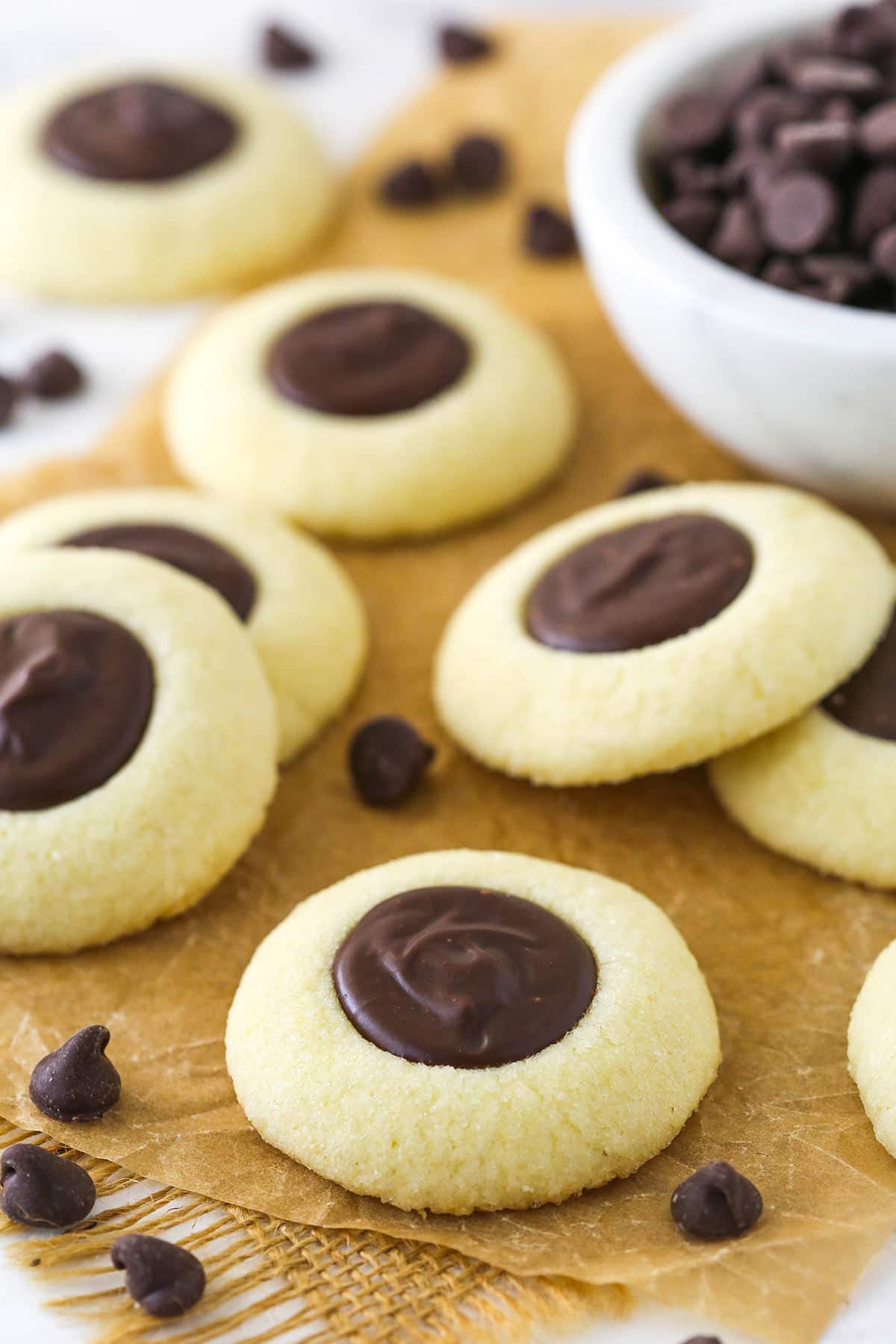 chocolate thumbprint cookies on brown parchment paper