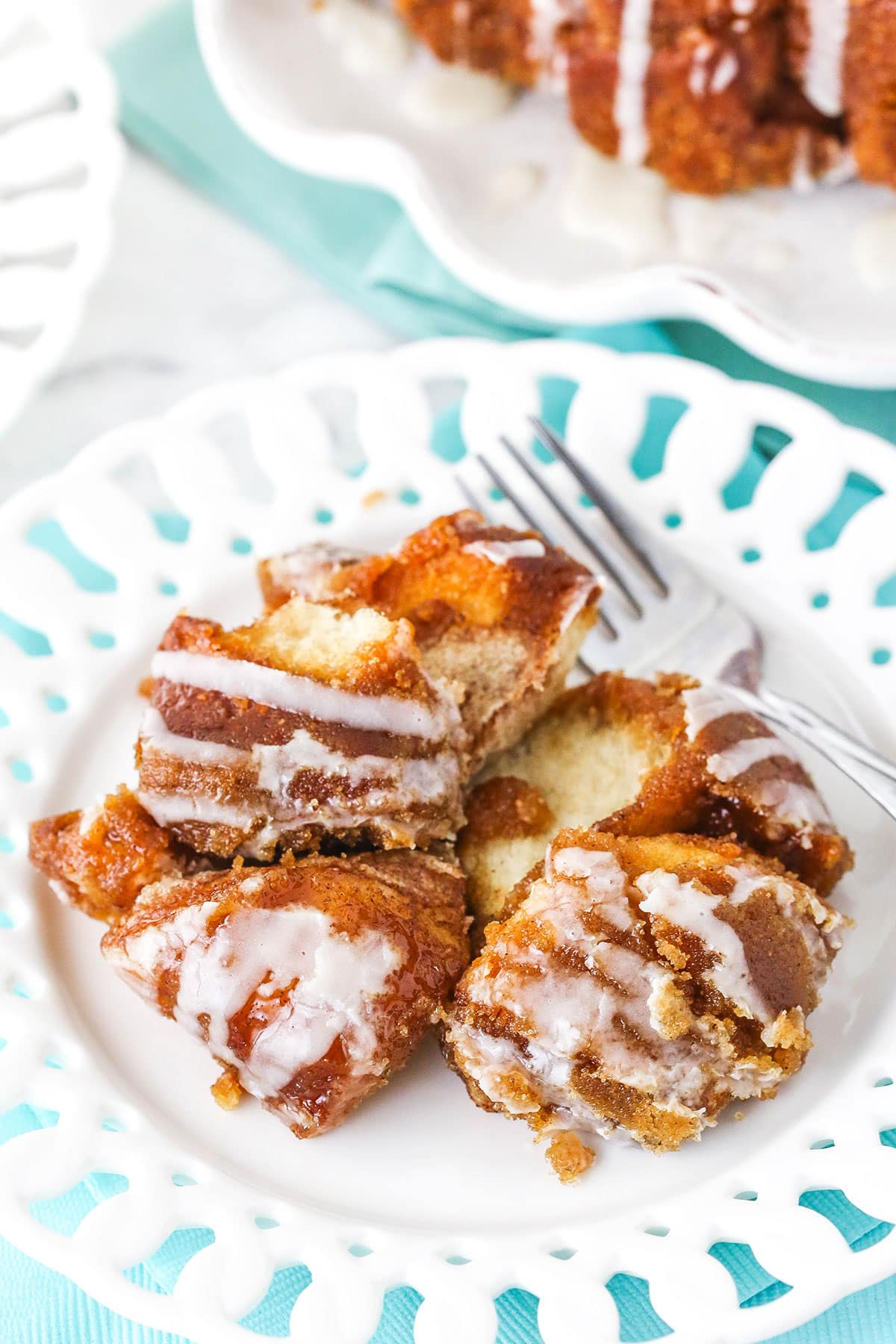 A white plate and fork with fluffy pieces of homemade monkey bread.