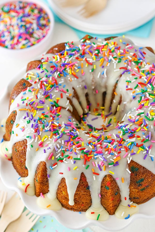 Top view of a whole Funfetti Bundt Cake with tons of colorful sprinkles and icing on top