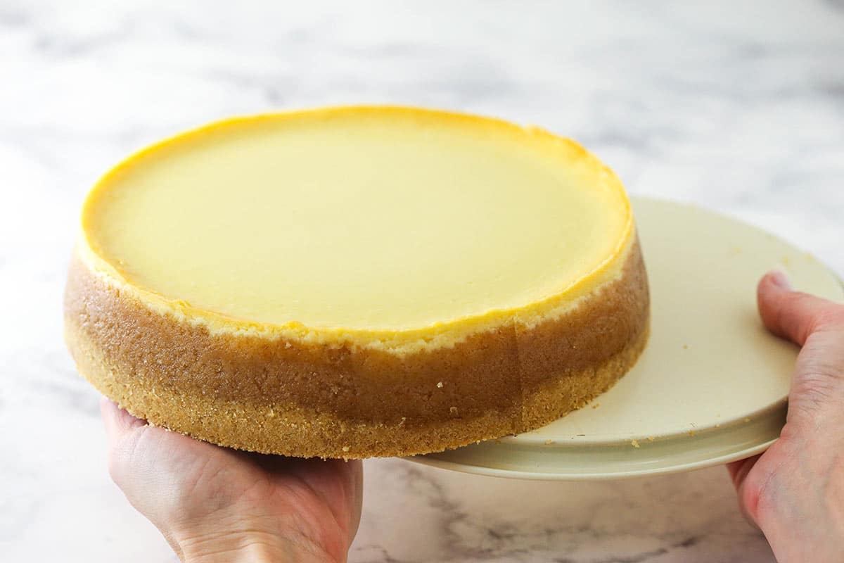 sliding the cheesecake off of the pan bottom onto the palm of my hand
