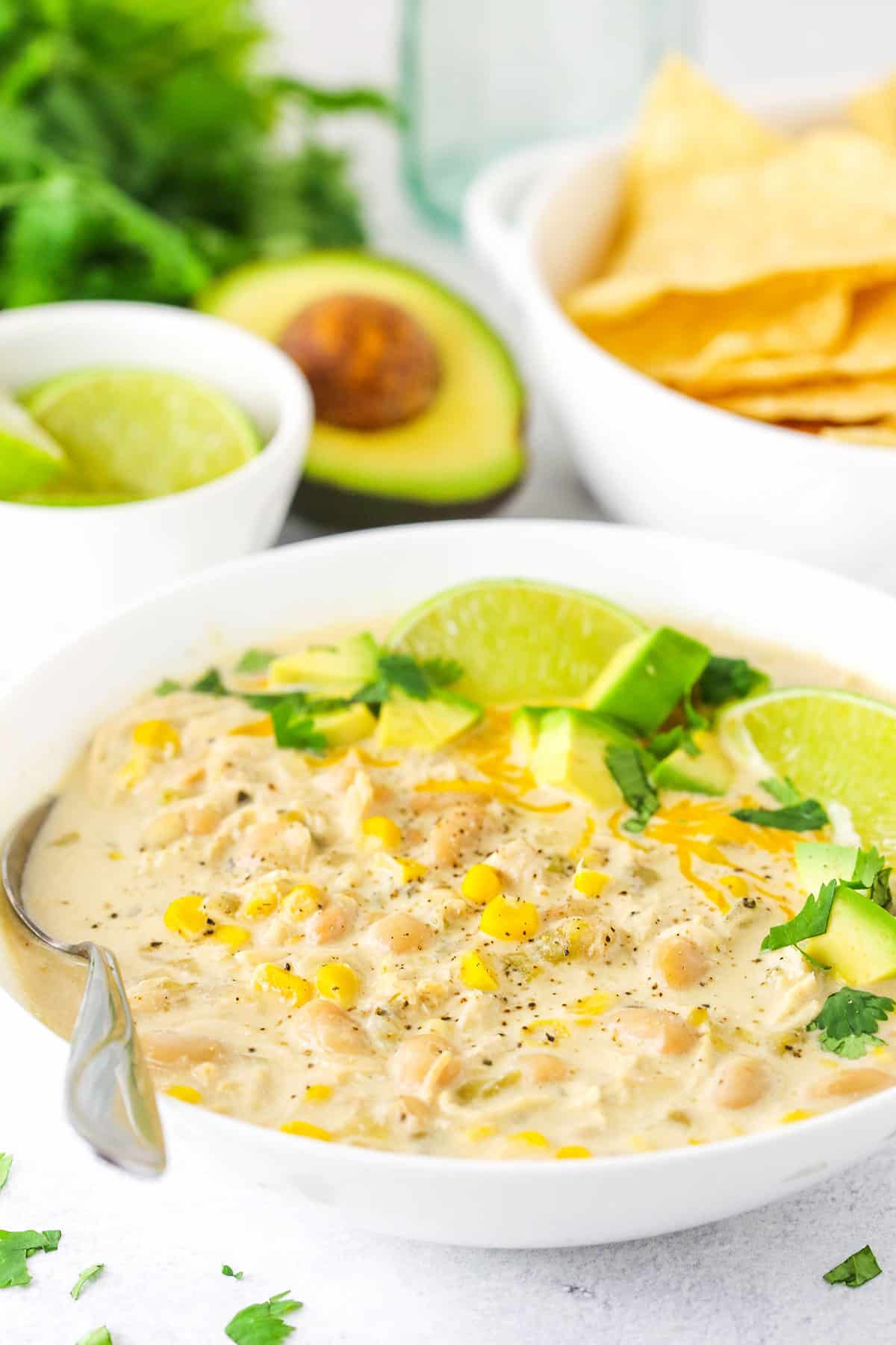 A Serving of White Chicken Chili with an Avocado and Tortilla Chips