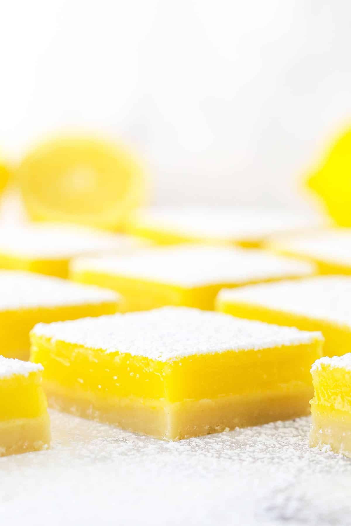 Side view of a lemon bar dusted with confectioners sugar