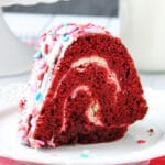 A slice of Layered Red Velvet Cheesecake Bundt Cake on a white plate