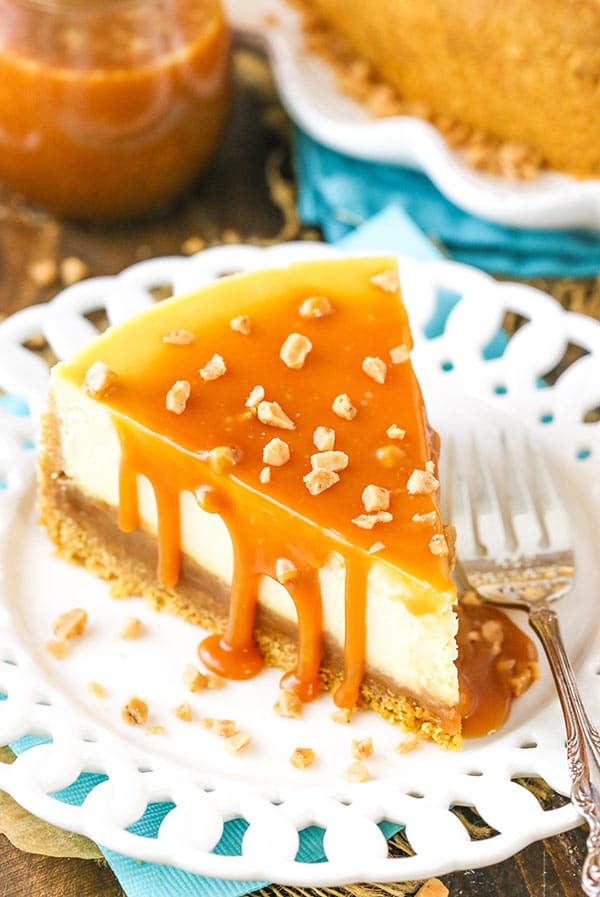 A slice of cheesecake covered in salted caramel and sprinkled with toffee bits